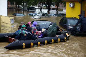 People evacuate in a boat in the flooded town of Obrenovac