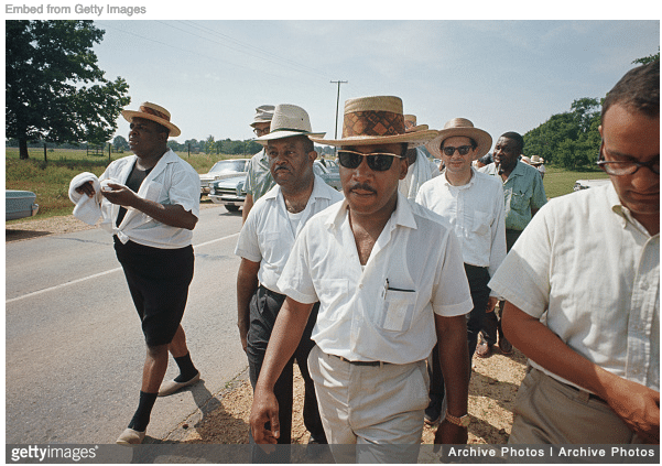 MLK marching in casual clothes and straw hat