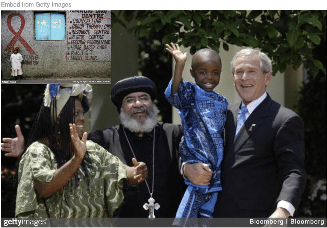 Bush holding African child at White House celebrating Worlds Aids Day with image of little African boy standing below Aids ribbon...