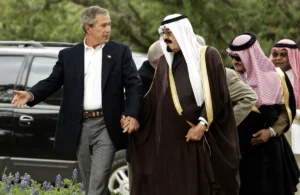 George W. Bush holding hands with King Abdullah
